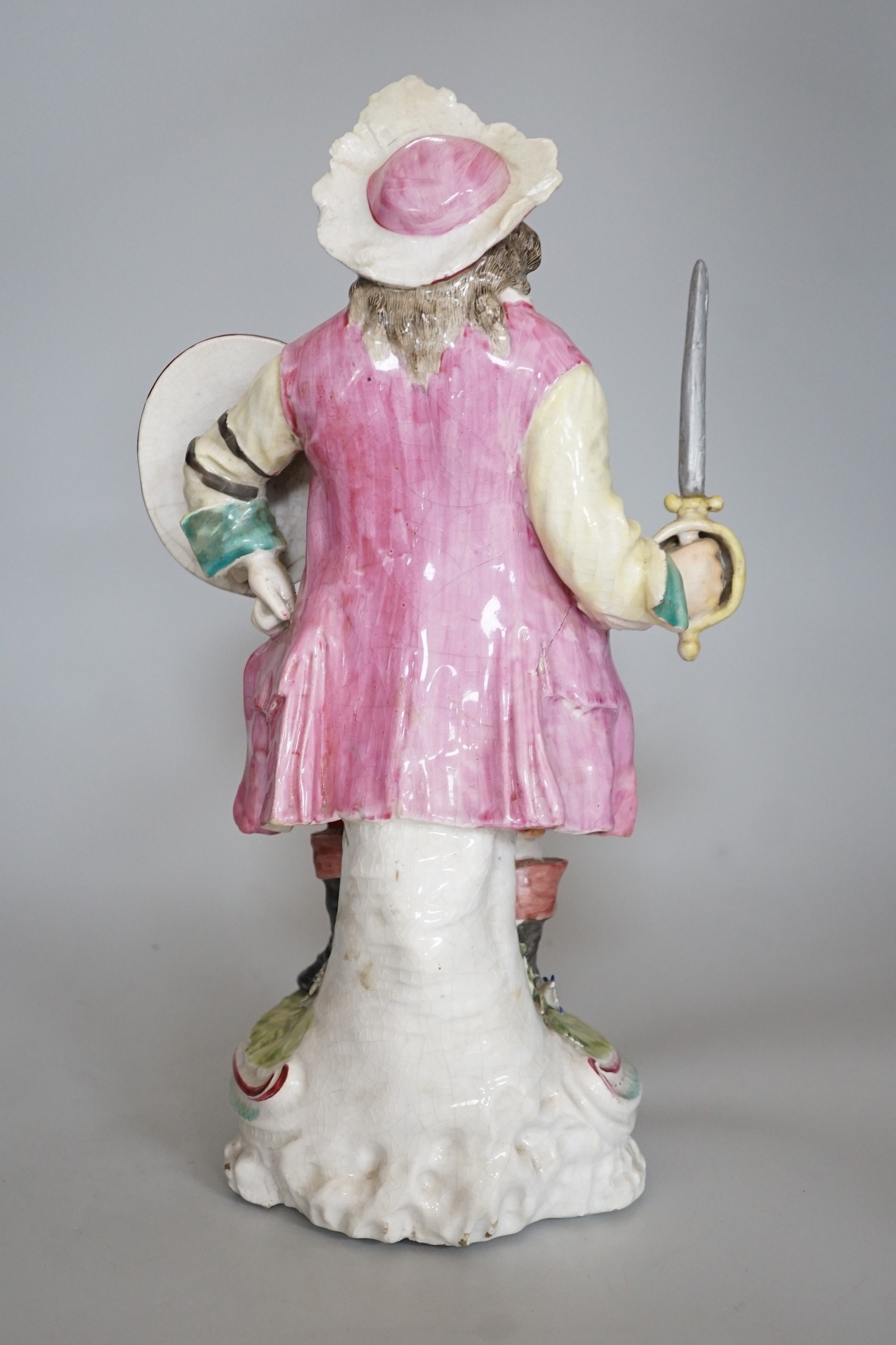 A large Derby figure of Falstaff standing, holding a sword and shield, patch marks, original brass sword, is now a modelled replacement, 39cms high